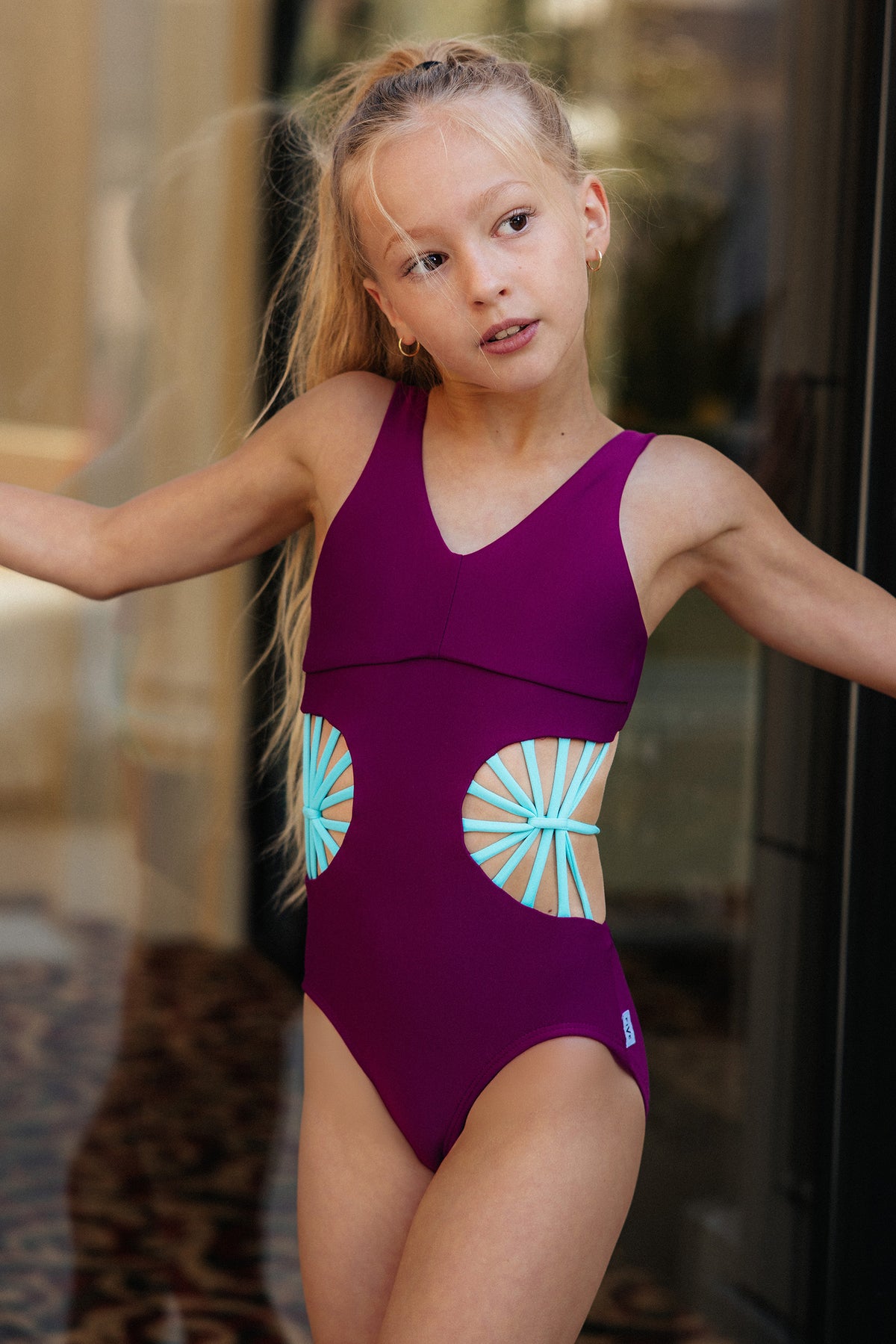 kids, a girl in a berry leotard with turquoise starburst cutout straps